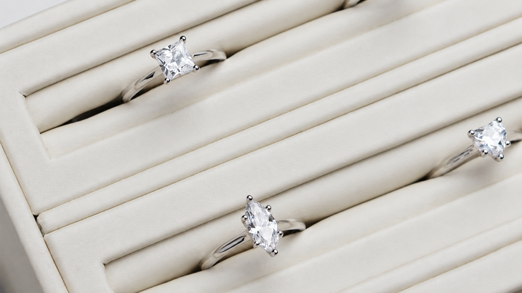Engagement rings on display against white ring holder